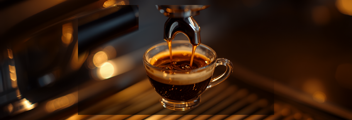 Espresso shot pouring from a portafilter into a small glass cup with rich crema