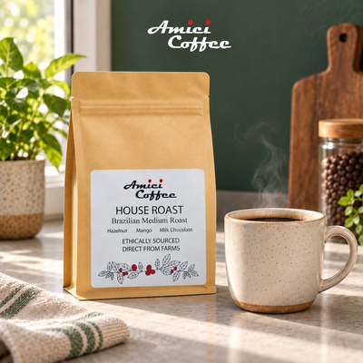 Amici House Roast coffee bag on a kitchen counter beside a freshly brewed cup